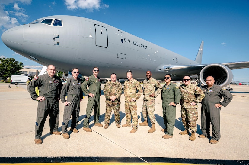 A group of military members stand in front of a KC-46A Pegasus