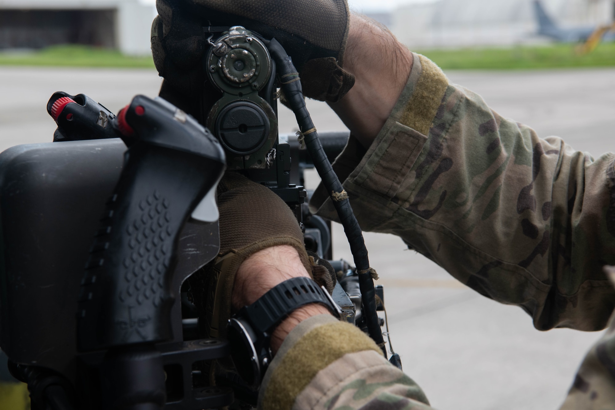 An Airman prepares a door gun on a helicopter.