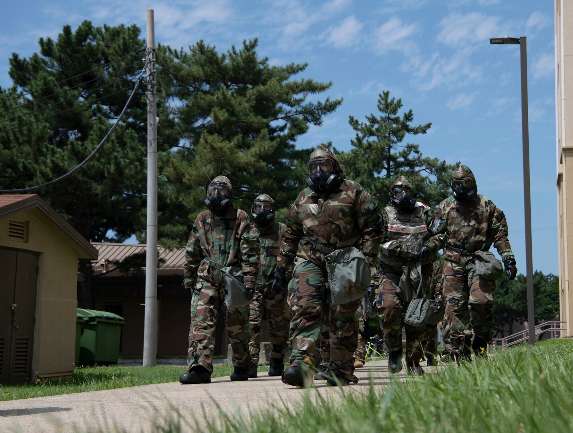 Airmen with the 8th Medical Group walk in mission oriented protective posture gear during a training event at Kunsan Air Base, Republic of Korea, Aug. 17, 2022. Training reinforces Airmen readiness, strengthens capabilities and ensures the Wolf Pack has the ability to defend the base, accept follow-on forces and take the fight north. (U.S. Air Force photo by Staff. Sgt Sadie Colbert)