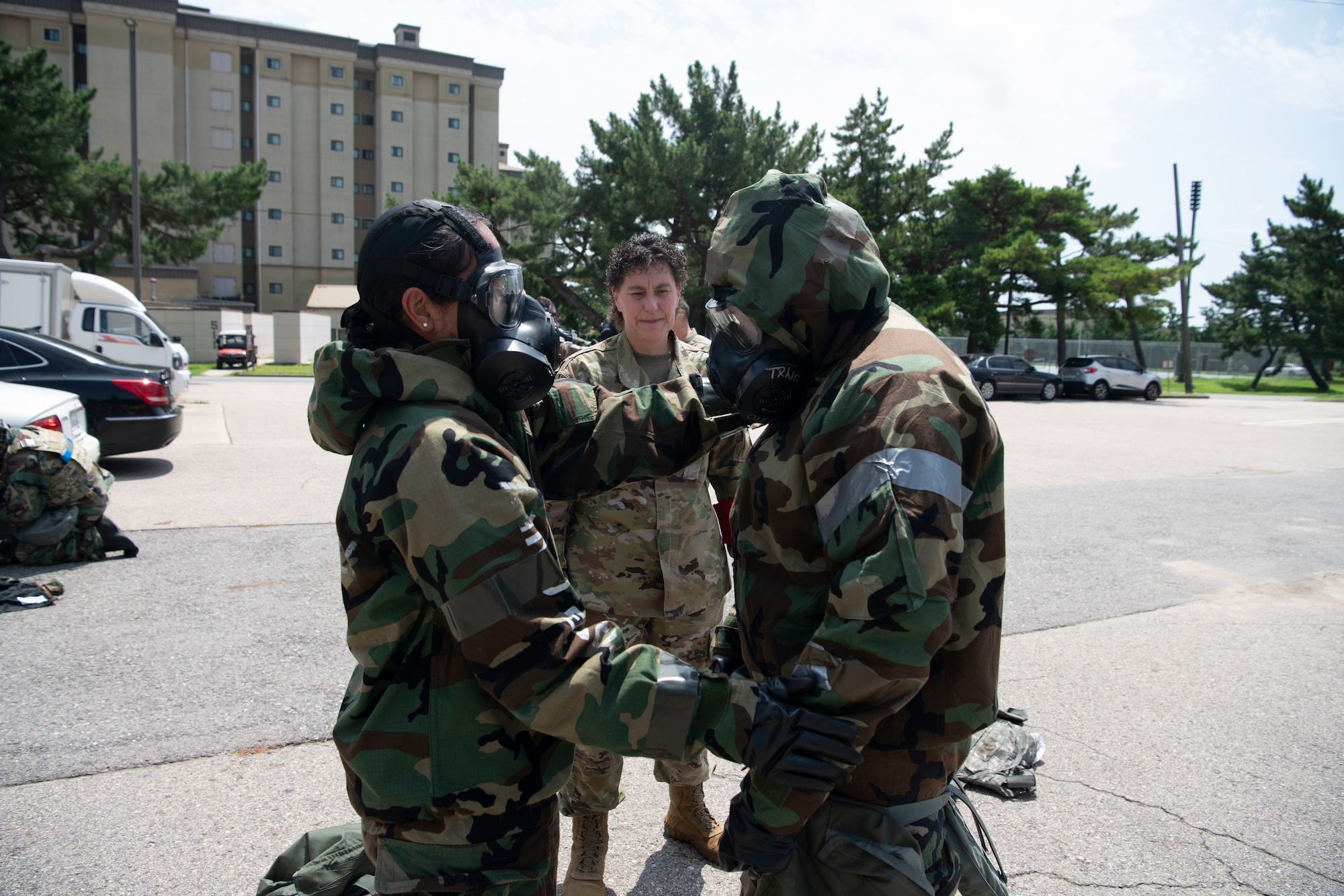 Lt. Col. Elisa Hammer (left), 8th Operational Medical Readiness Squadron commander, CMSgt. Lisa Pickett (center), 8th Medical Group senior enlisted leader, and Lt. Col. Roselyn Fuentes, 8th MDG aerospace medical chief, perform a buddy check during a training event at Kunsan Air Base, Republic of Korea, Aug. 17, 2022. Training reinforces Airmen readiness, strengthens capabilities and ensures the Wolf Pack has the ability to defend the base, accept follow-on forces and take the fight north. (U.S. Air Force photo by Staff. Sgt Sadie Colbert)