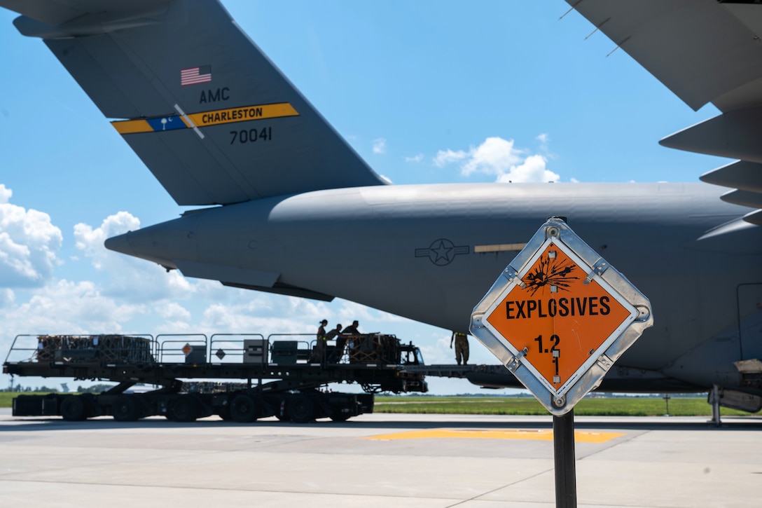 An explosives sign marks the perimeter around a military aircraft.