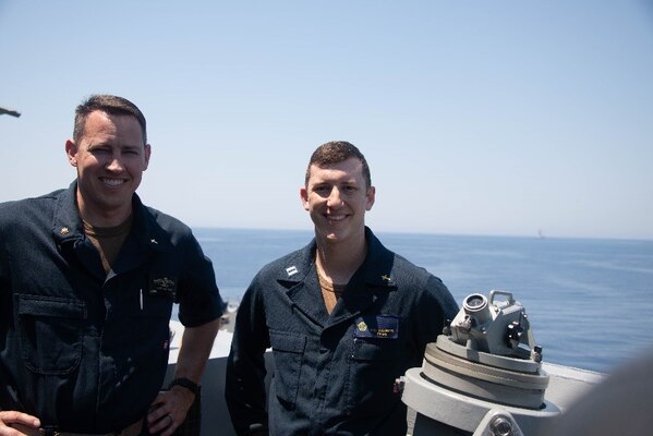 Chaplain Lt. Cmdr. Elias Paulk, left embarked aboard Arleigh Burke-class guided-missile destroyer USS Forrest Sherman (DDG 98), and Lt. Rene Pellessier, embarked aboard Nimitz-class aircraft carrier USS Harry S. Truman (CVN 75), stand on Forrest Sherman’s bridge wing prior to a Roman Catholic Mass service, July 24, 2022.