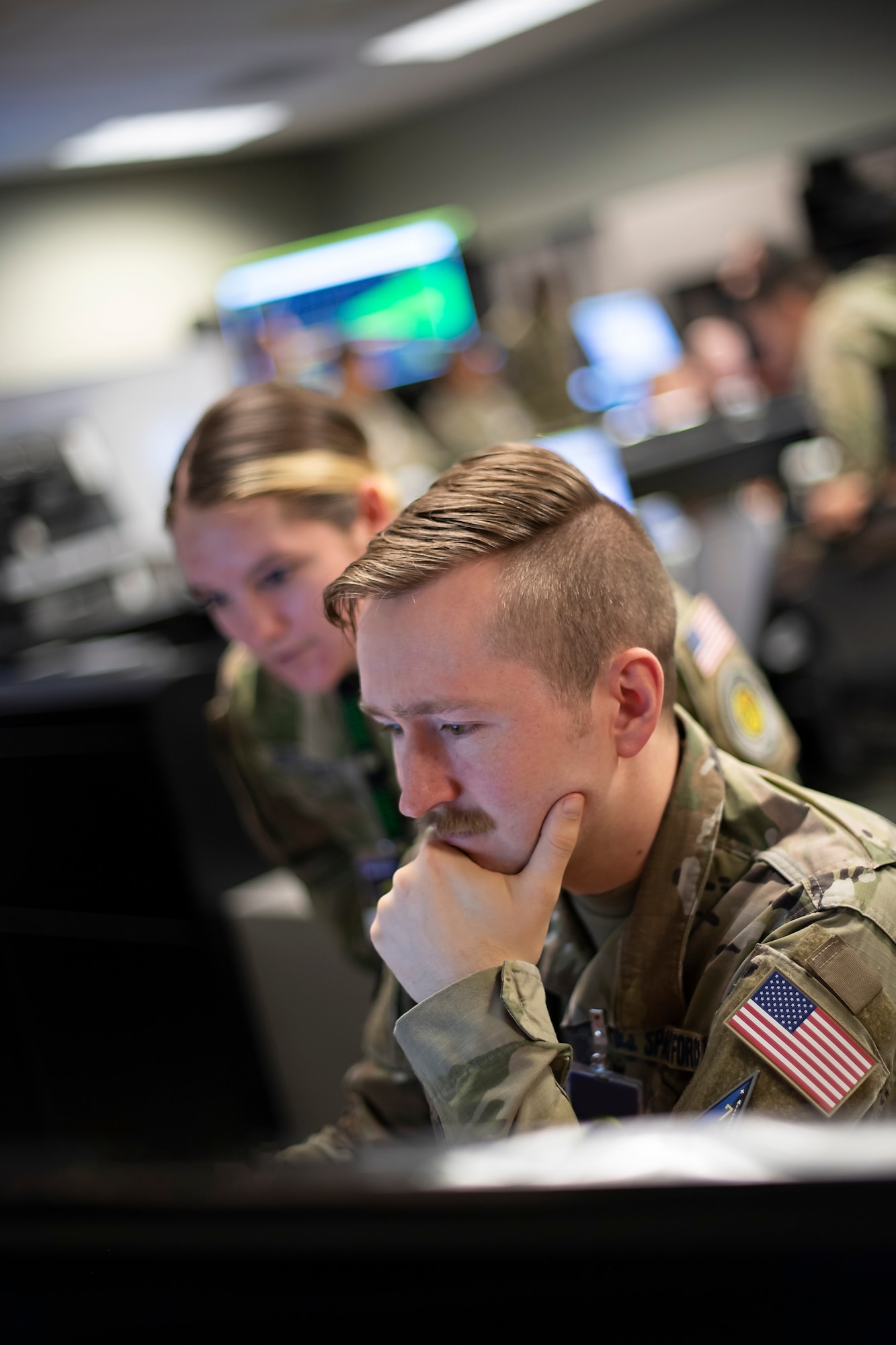 U.S. Space Force Sgt. Cassidy Basney, left, and Specialist 4 Neale Hart provide intelligence assessments to drive simulated combat operations