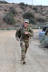 A soldier ruck marches on a dirt road