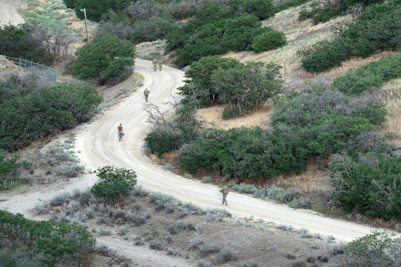 Soldiers ruck march on a dirt road