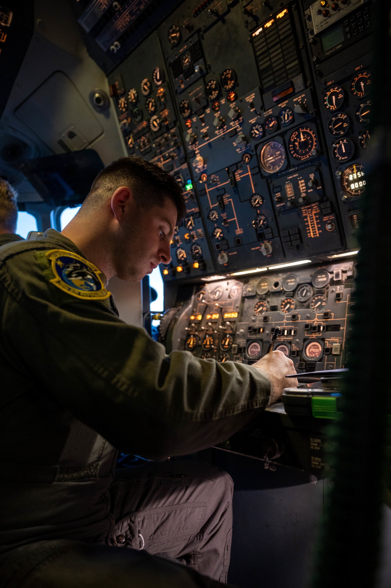 An Airman completes a preflight checklist in a cockpit of an aircraft