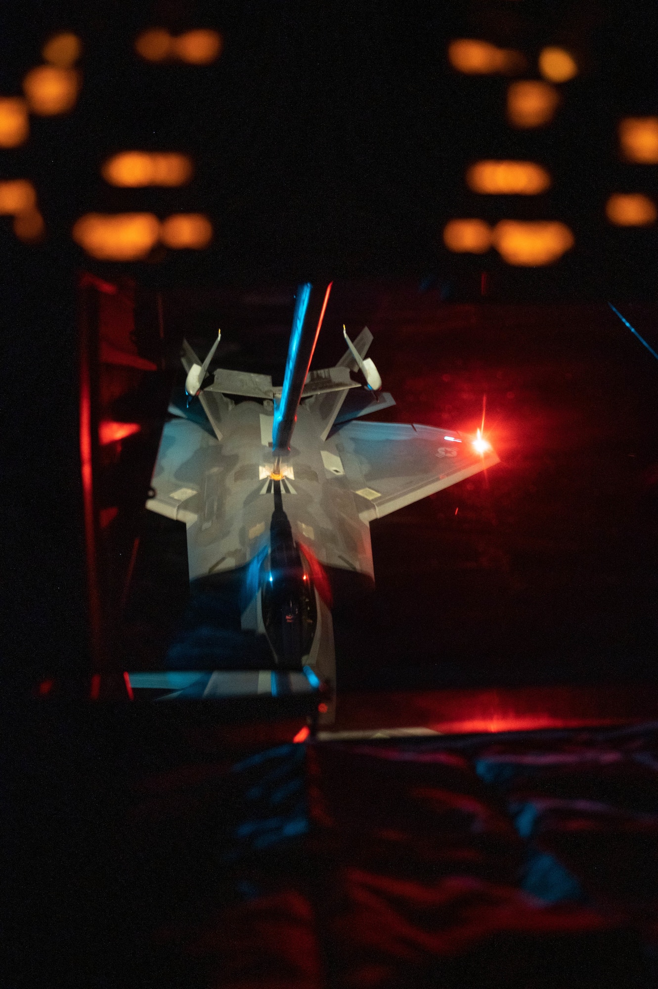 An F-22 is connected to a boom during in-flight refueling