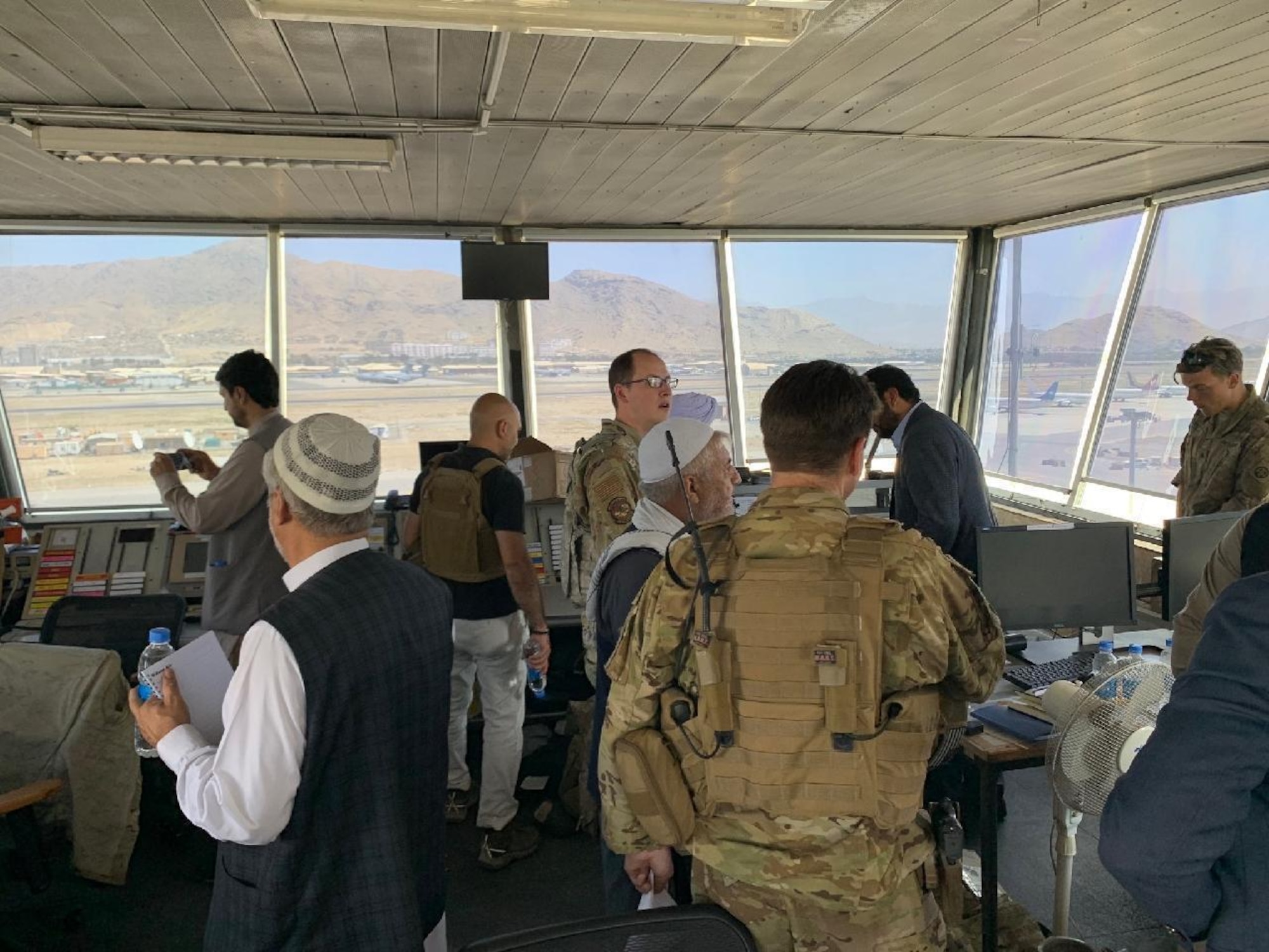 Captain Adam Solomon, 332nd Expeditionary Operations Support Squadron airfield operations flight commander, shows senior Taliban members what is needed to resume operations of the air traffic control tower August, 2021, at Hamid Karzai International Airport (HKIA), Afghanistan.