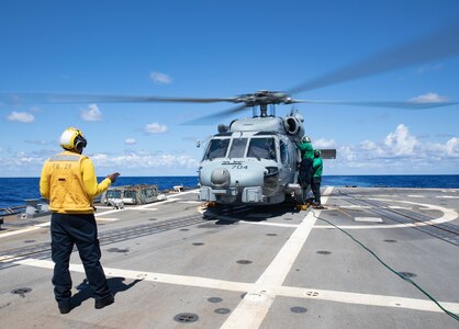 Sailors perform maintenance checks on an MH-60R Sea Hawk helicopter, attached to Helicopter Maritime Strike Squadron (HSM) 48, on the flight deck aboard the Arleigh Burke-class guided-missile destroyer USS Truxtun (DDG 103).