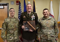 Soldier receives award plaque from Brigade Leaders