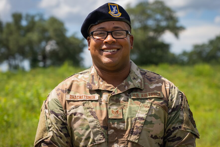 Security forces Airman in black beret and glasses smiles while posing for a photo.