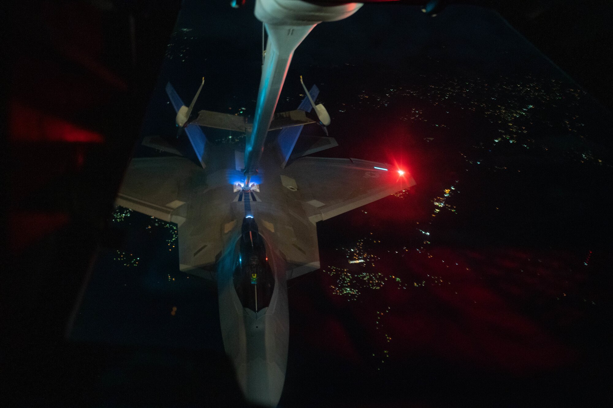 A F-22 Raptor is connected to a boom during an in-flight refueling mission.