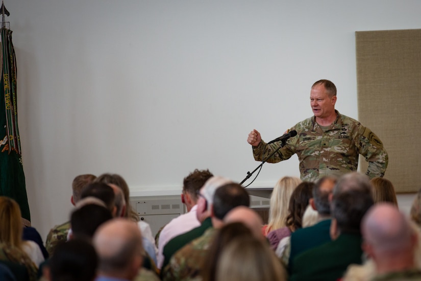 A soldier standing at a podium gives a speech to an audience.