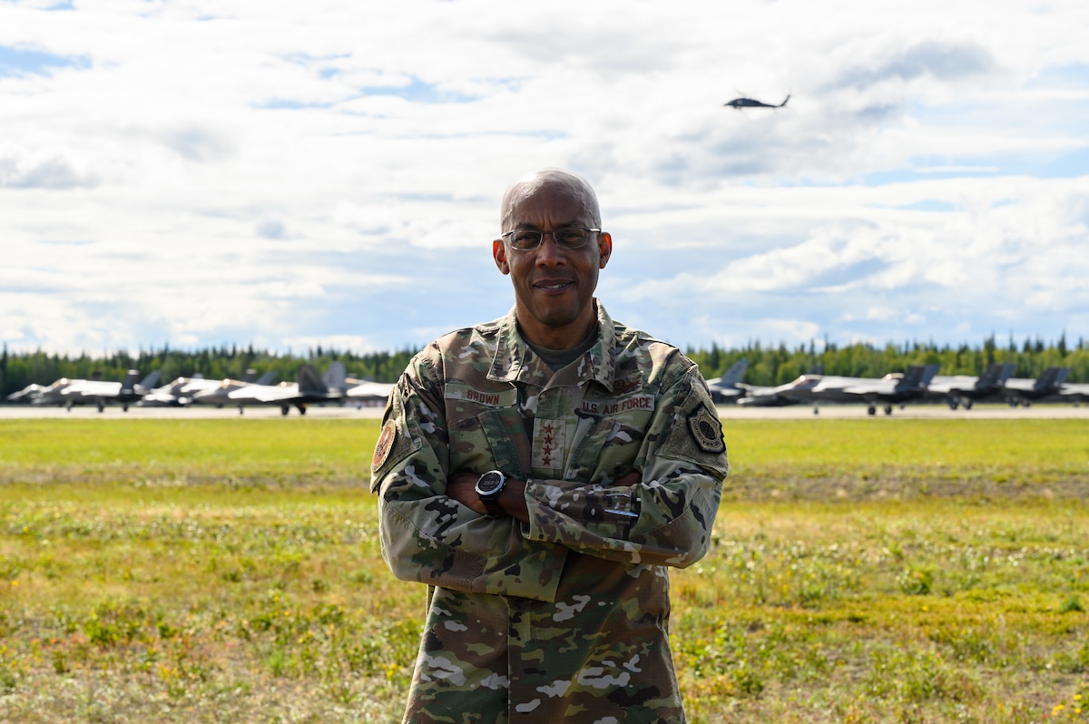 U.S. Air Force Chief of Staff Gen. CQ Brown, Jr. poses in front of an aircraft formation during a routine readiness exercise on Eielson Air Force Base, Alaska, Aug. 12, 2022.