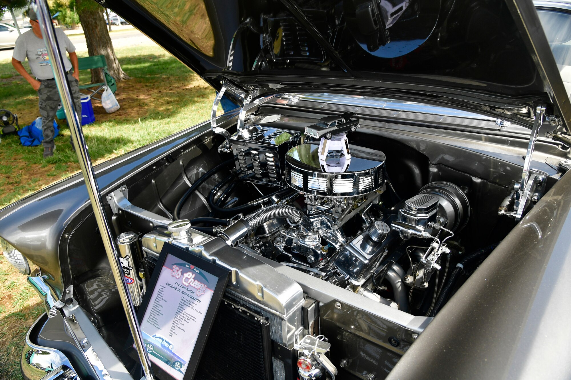 The engine under the hood of a silver 1956 Chevy 210 2-DR Sedan