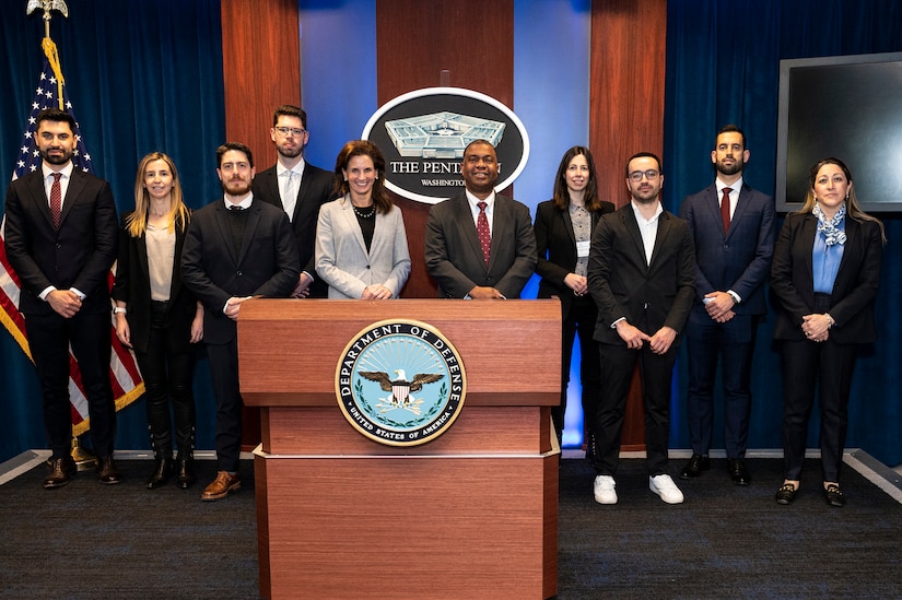 A group of men and women poses for a photo.