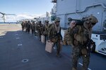 U.S. Marines assigned to the 31st Marine Expeditionary Unit (MEU) prepare to board aircraft on the flight deck aboard amphibious assault carrier USS Tripoli (LHA 7), Aug. 16, 2022. Tripoli is operating in the U.S. 7th Fleet area of operations to enhance interoperability with allies and partners and serve as a ready response force to defend peace and maintain stability in the Indo-Pacific region.