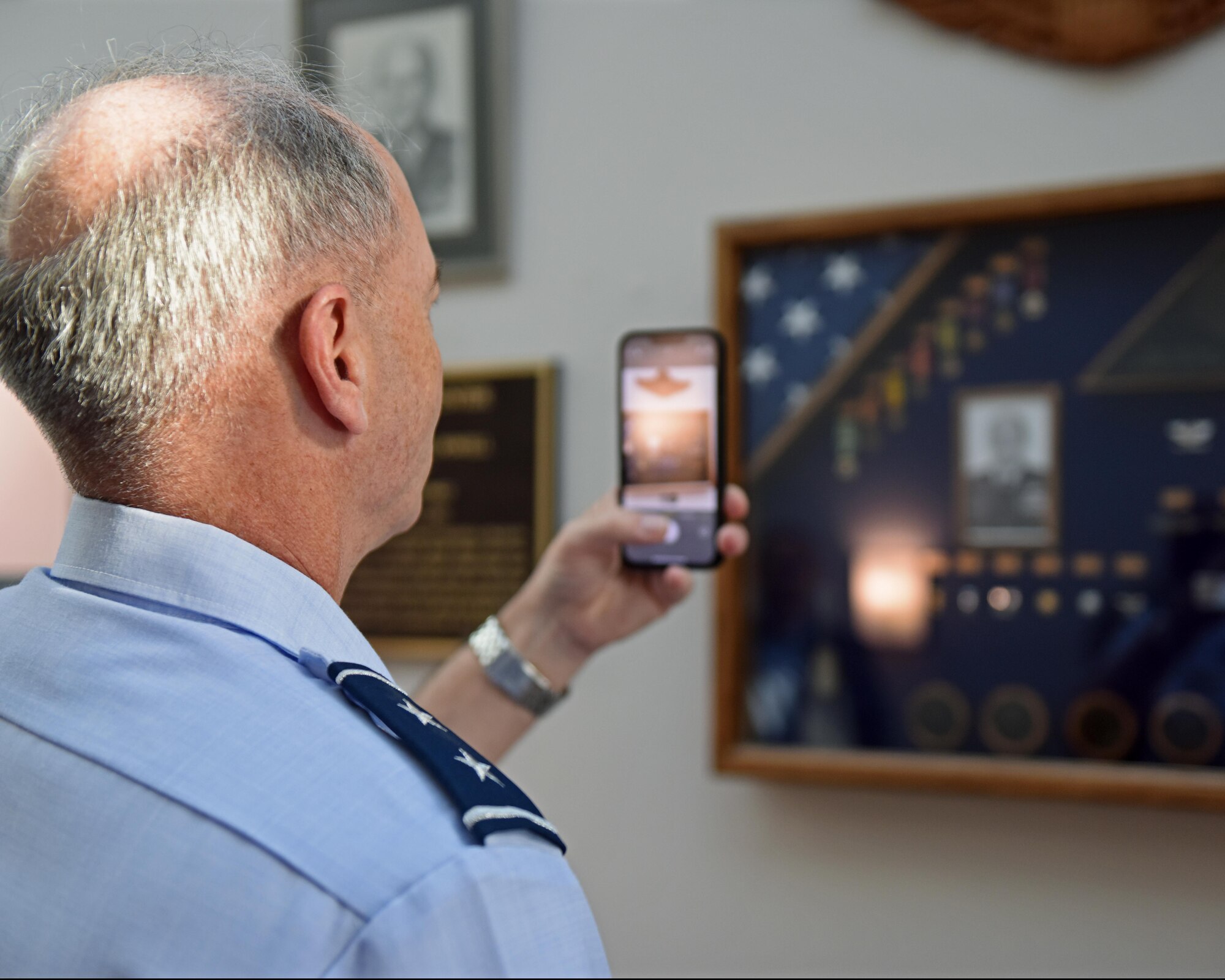 U.S. Air Force Maj. Gen. Michael Downs, Joint Staff deputy director for intelligence, surveillance and reconnaissance operations; and director, Joint Intelligence, Surveillance and Reconnaissance Operations Center; takes a photo of the Charles Powell dedication at the Powell Event Center, Goodfellow Air Force Base, Texas, Aug. 17, 2022. The event center was renamed the Powell Event Center to honor U.S. Air Force retired Col. Charles E. Powell, a previous commander of the 3480th Technical Training Wing at Goodfellow, on Sept. 10, 2021. (U.S. Air Force photo by Airman 1st Class Sarah Williams)