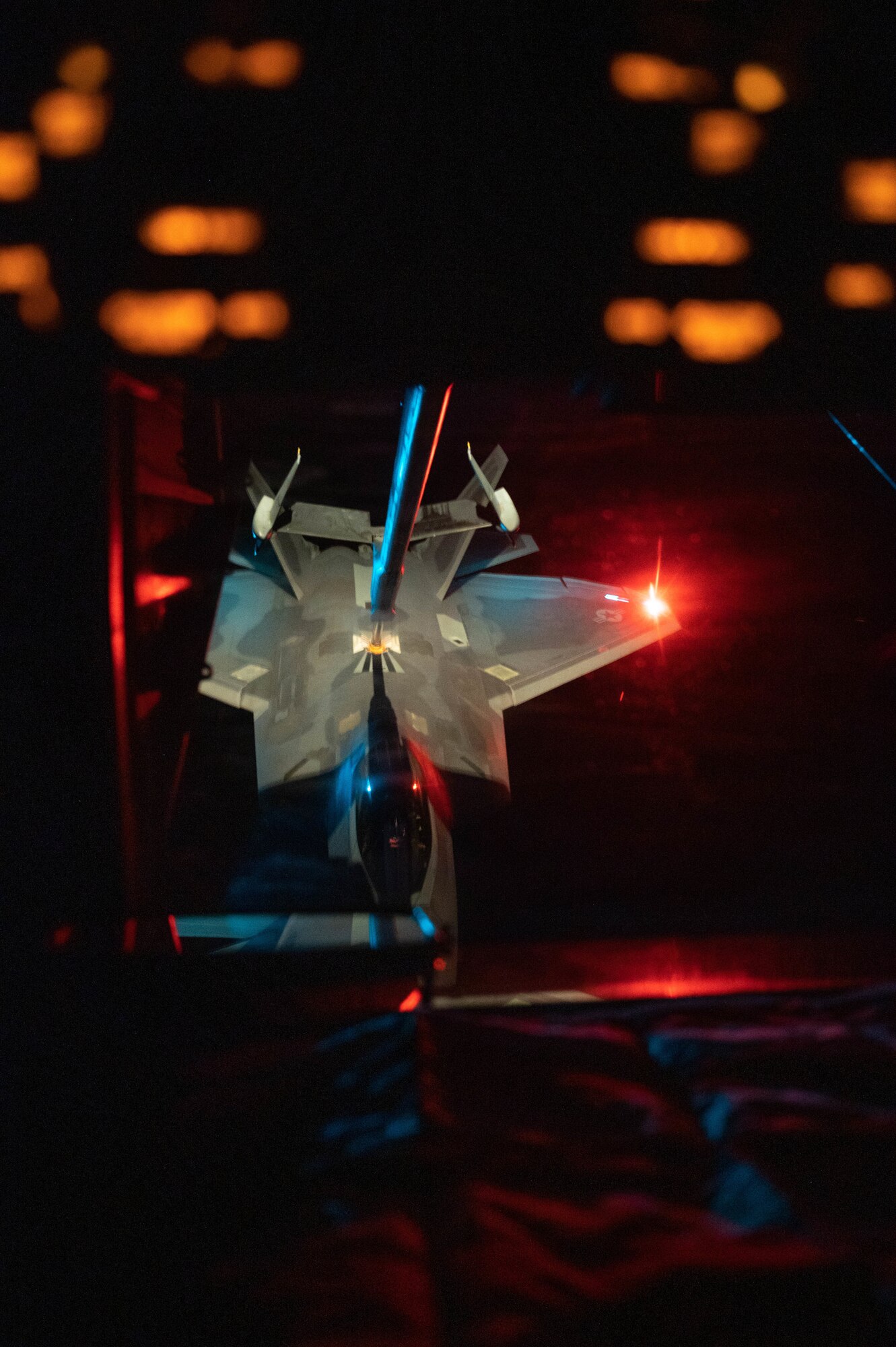 An F-22 is connected to a boom during in-flight refueling