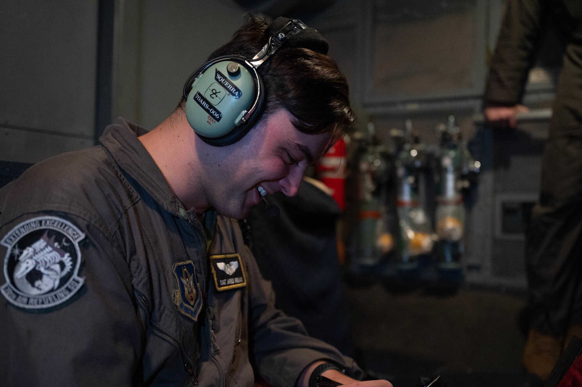 A boom operator smiles as he looks down to record data while in-flight.