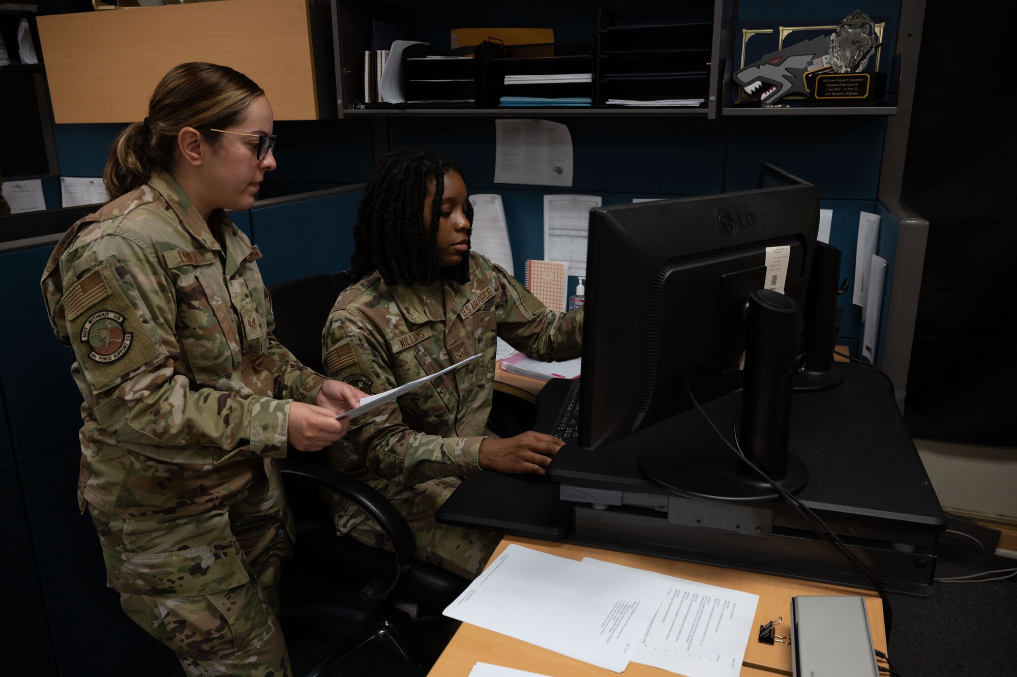 Two Airmen work with a computer to complete their training.