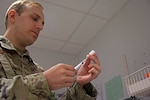 U.S. Air Force Staff Sgt. Joseph Holweger, 86th Medical Group non-commissioned officer in charge of the Immunizations Clinic, prepares a vaccine at Ramstein Air Base Germany, Aug. 18, 2022. Holweger and the rest of his team at the immunizations Clinic on base are prepared to issue the Novavax vaccine to those interested. (U.S. Air Force photo by Senior Airman Thomas Karol)