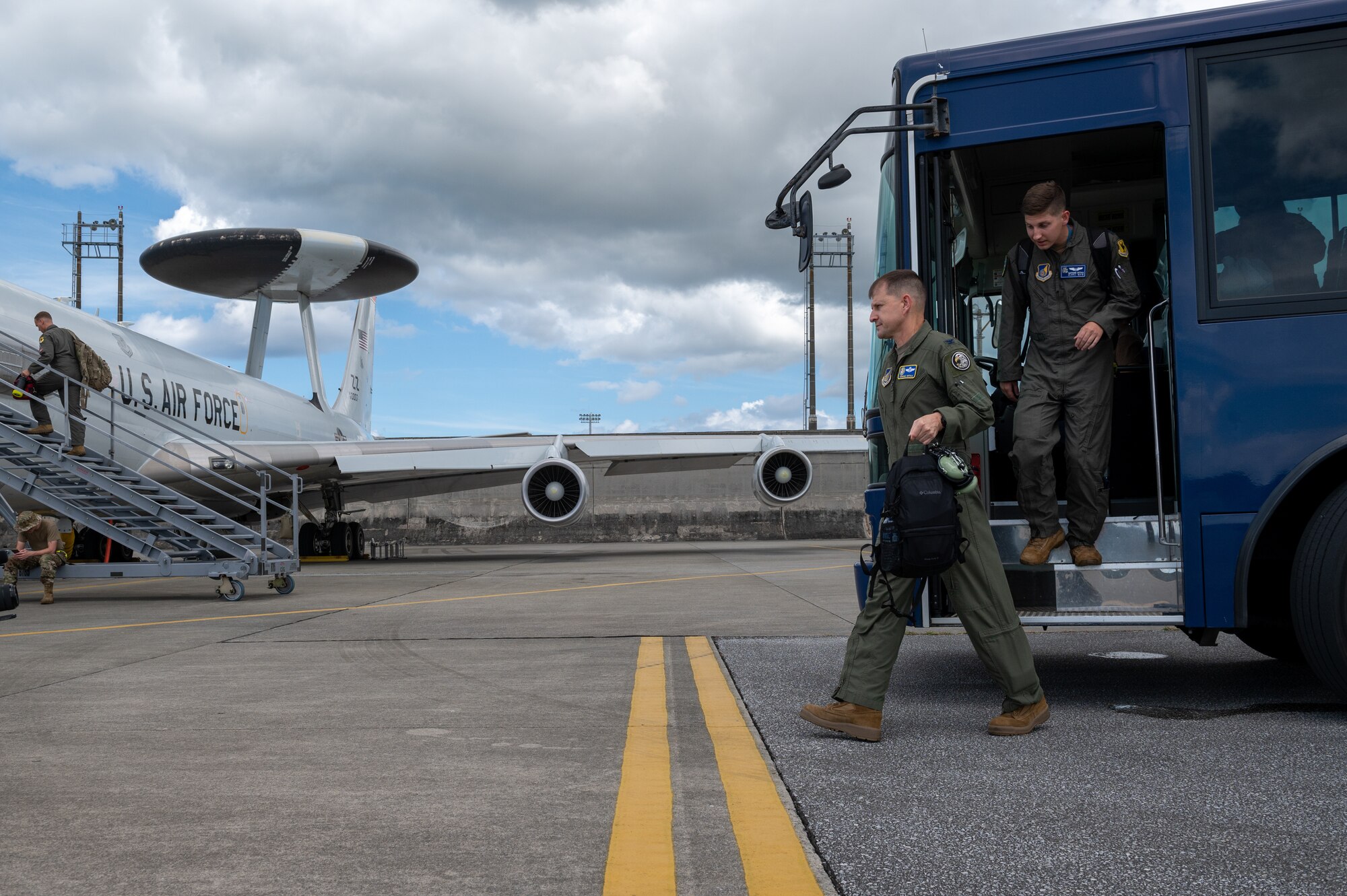 Father and son get off a bus to walk to an aircraft