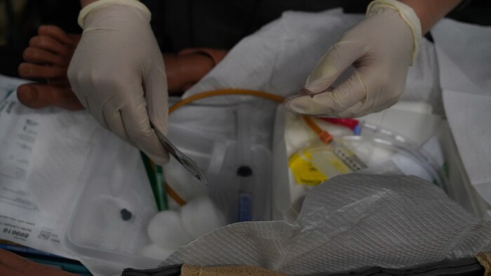 Hands wearing gloves, keeping an area sterile