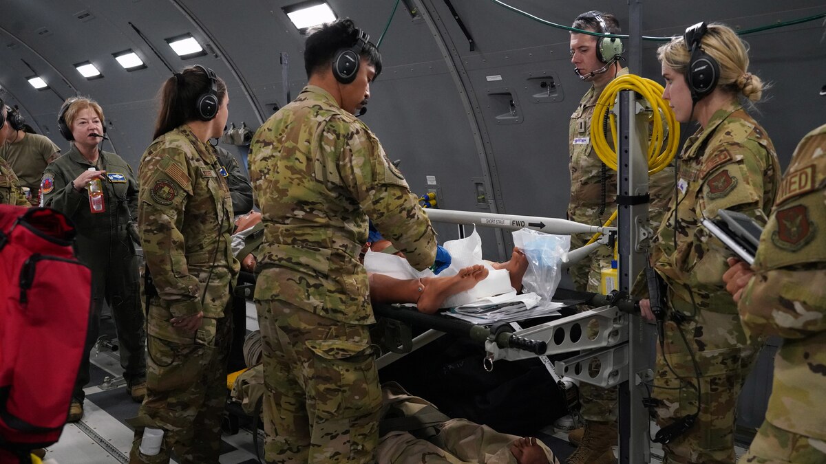 One male medical technician does a procedure while others watch.