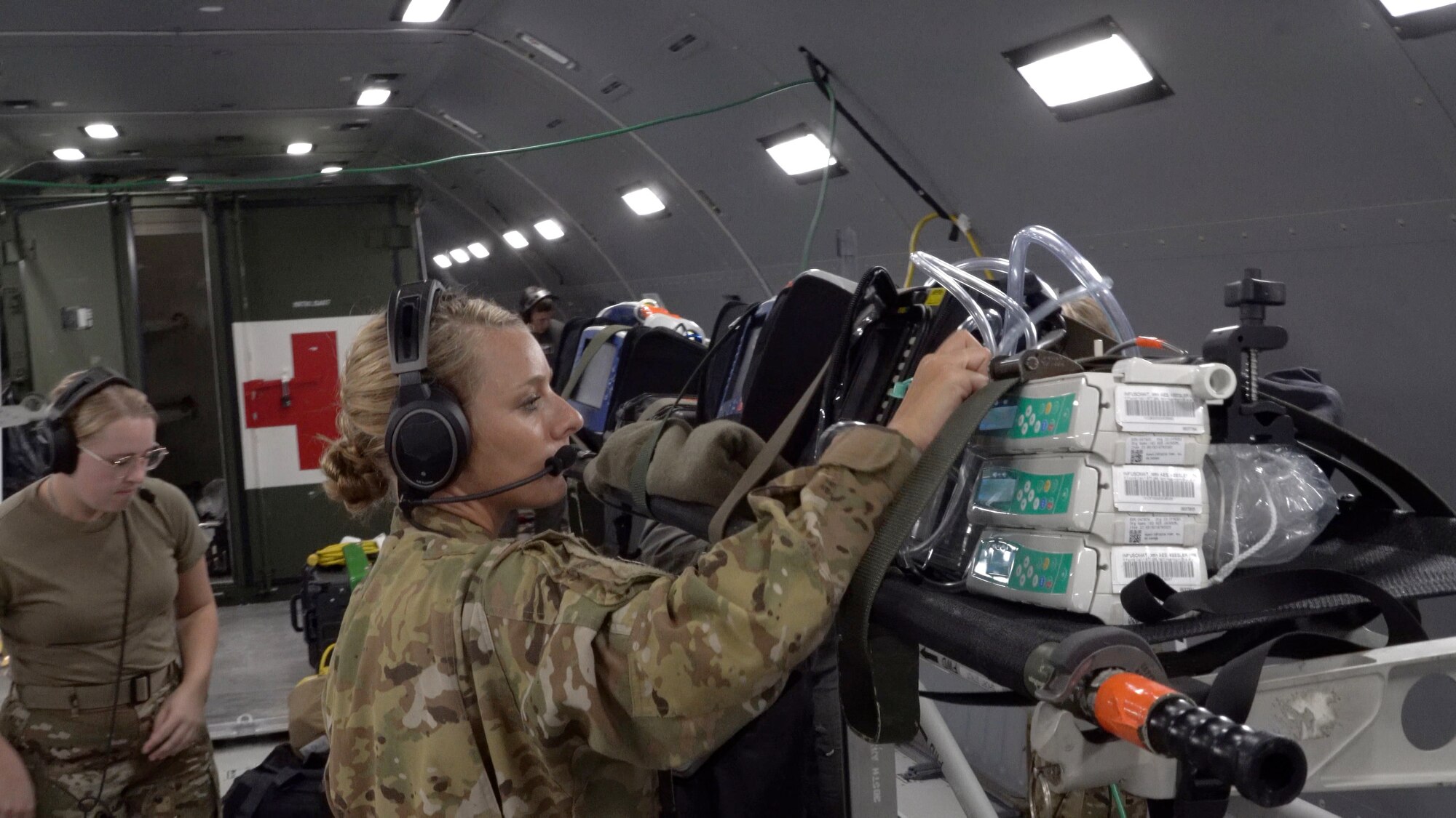Capt. Elizabeth Beaty stands next to a litter holding supplies and checks the equipment.