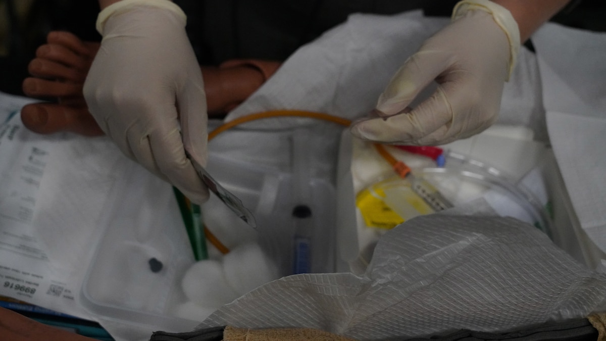 Hands wearing gloves, keeping an area sterile