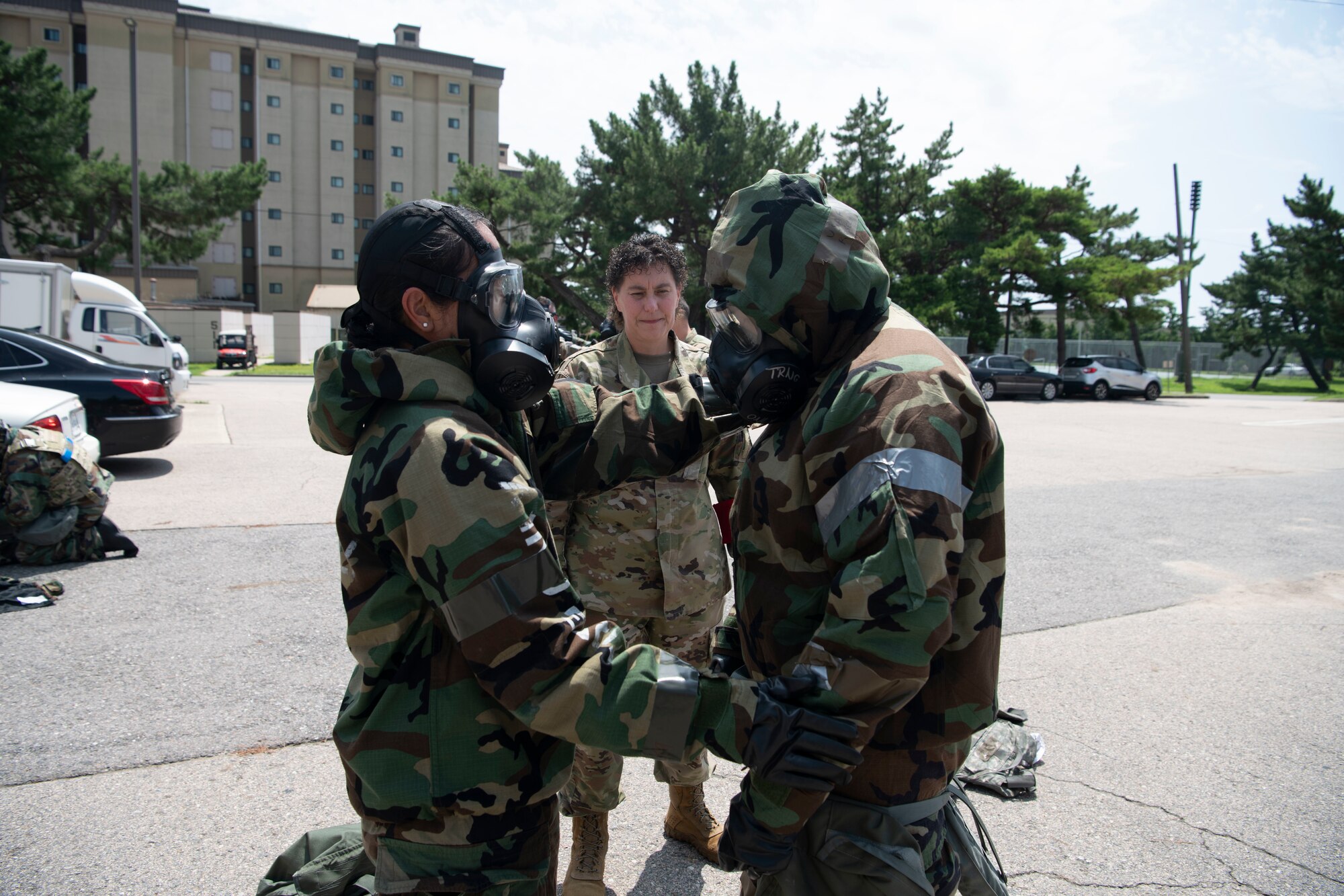 Lt. Col. Elisa Hammer (left), 8th Operational Medical Readiness Squadron commander, CMSgt. Lisa Pickett (center), 8th Medical Group senior enlisted leader, and Lt. Col. Roselyn Fuentes, 8th MDG aerospace medical chief, perform a buddy check during a training event at Kunsan Air Base, Republic of Korea, Aug. 17, 2022. Training reinforces Airmen readiness, strengthens capabilities and ensures the Wolf Pack has the ability to defend the base, accept follow-on forces and take the fight north. (U.S. Air Force photo by Staff. Sgt Sadie Colbert)