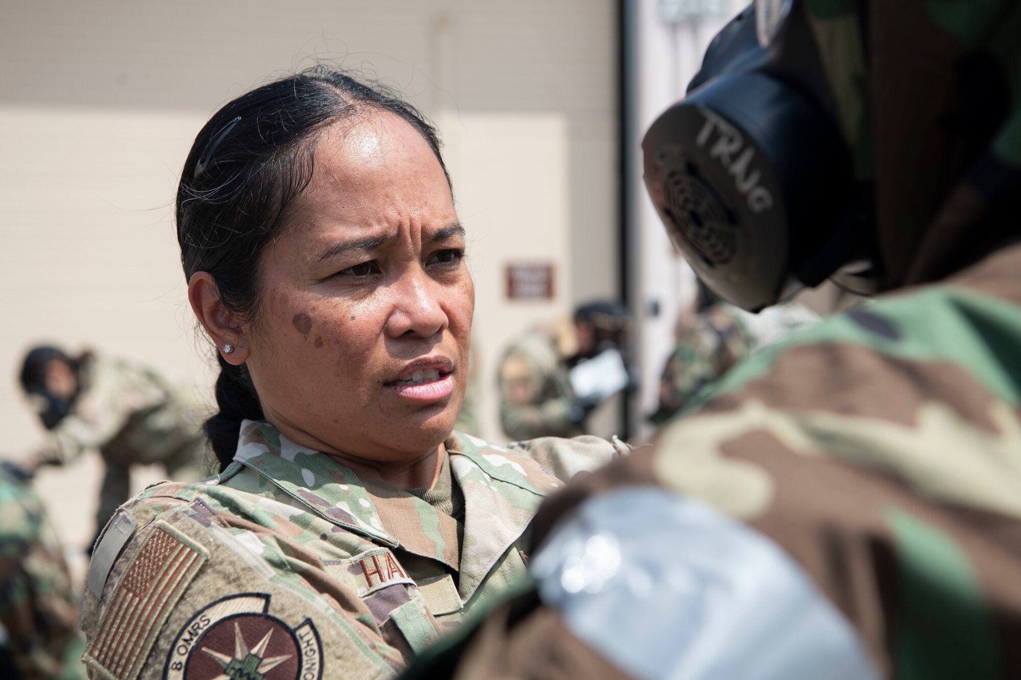 Lt. Col. Elisa Hammer, 8th Operational Medical Readiness Squadron commander, performs a buddy check during a training event at Kunsan Air Base, Republic of Korea, Aug. 17, 2022. Training reinforces Airmen readiness, strengthens capabilities and ensures the Wolf Pack has the ability to defend the base, accept follow-on forces and take the fight north. (U.S. Air Force photo by Staff. Sgt Sadie Colbert)