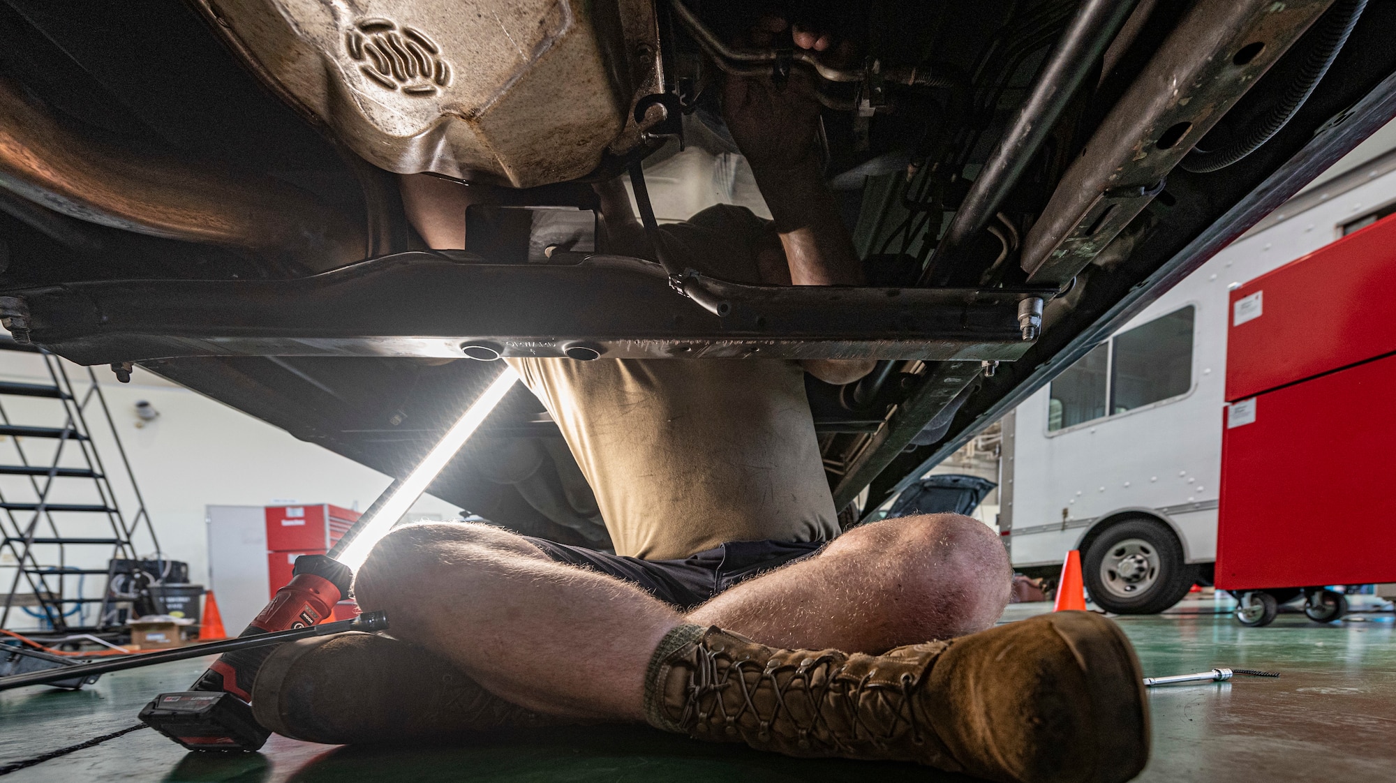 Airman 1st Class Theodore Ellis, 374th Logistics Readiness Squadron vehicle maintenance journeyman, reattaches oil lines to the transmission at Yokota Air Base, Japan, Aug. 17, 2022.