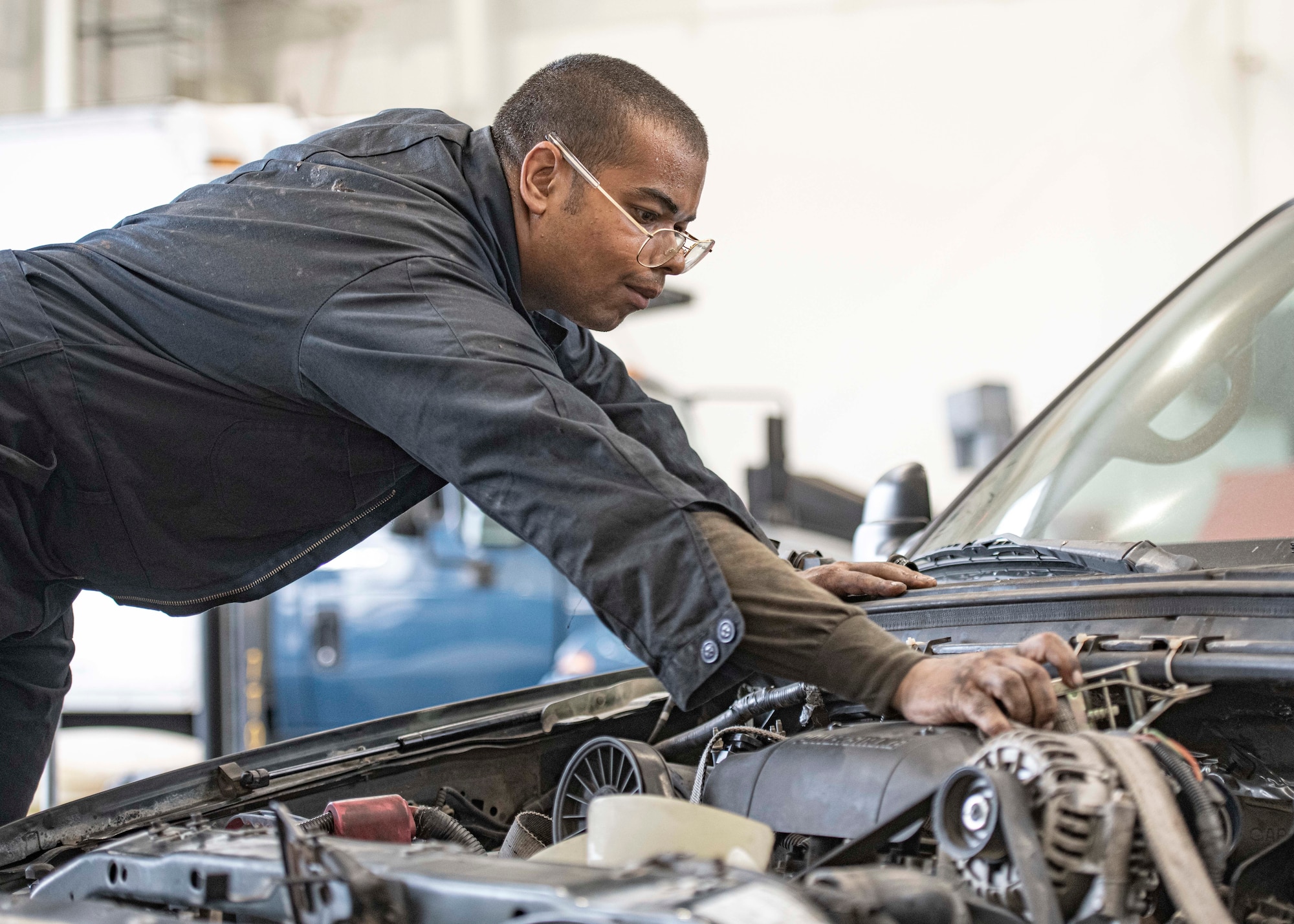 Airman 1st Class Jonathan Fana, 374th Logistics Readiness Squadron Vehicle Maintenance Flight journeyman, prepares to lift an engine out of a government vehicle at Yokota Air Base, Japan, Aug. 17, 2022.