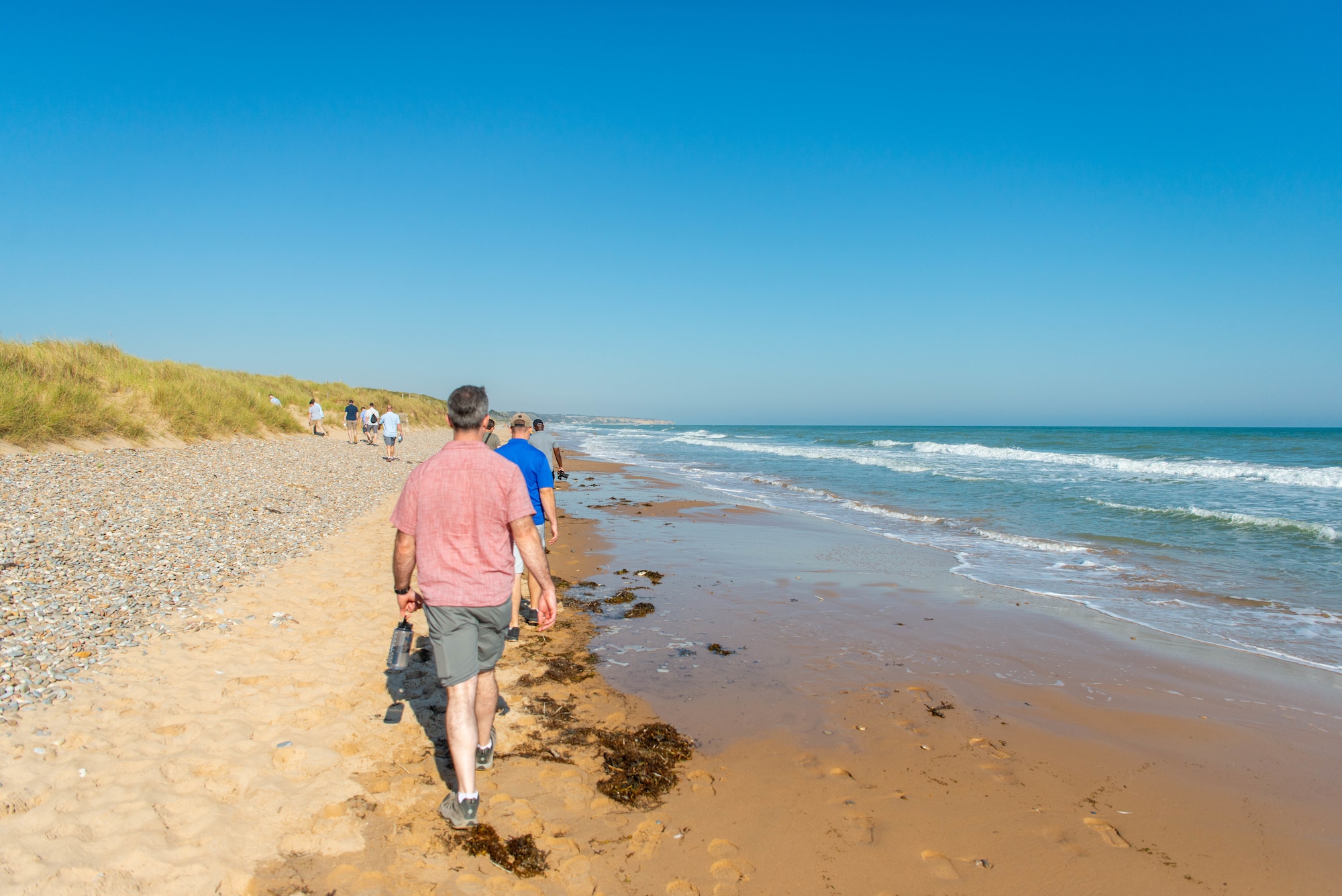 people walk along beach