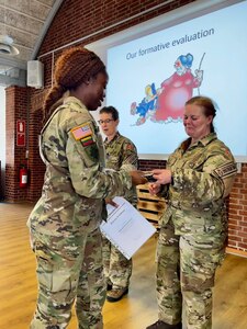 Capt. Shaneka Ashman, operations officer for the 143rd Regional Support Group, receives a certificate of completion for the Military Reserve Exchange Program at Camp Nymindegab in Denmark around July 8, 2022. Ashman was one of approximately 50 American Soldiers who participated in the course alongside approximately 90 NATO students.