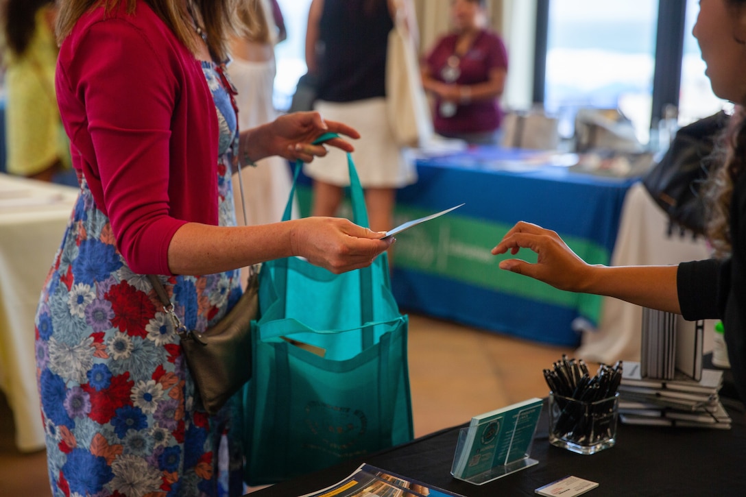 A spouse of a senior ranking military member receives information from the Marine Corps Family Advocacy program during an event at La Casa Del Mar on Marine Corps Base Camp Pendleton, California, Aug. 18, 2022. The event showcased the resources available to help Marine spouses and their families stationed aboard Marine Corps Installations West. Resources include but are not limited to Marine Corps Family Advocacy program, United Service Organization and others. There are over 15 different resources available to families and ways to help the communities across the installations. (U.S. Marine Corps photo by Lance Cpl. Straley)