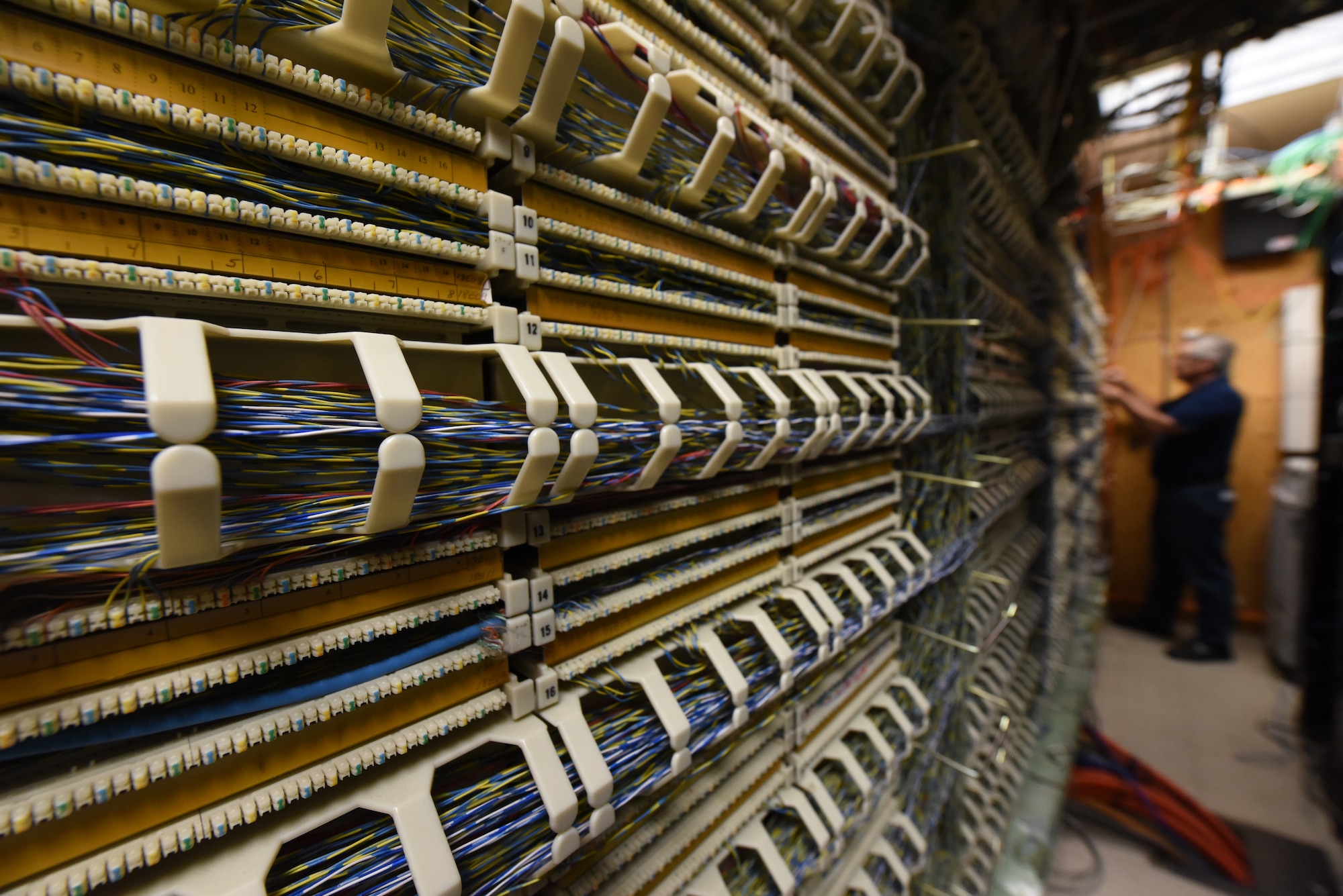 Matt Dodds, 21st Communications Squadron infrastructure branch chief, inspects the cable management of the telephone switch inside a server room at Peterson Space Force Base, Colorado, Aug. 12, 2022.