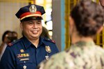 Police Lieutenant Douglas Sabando speaks to Ensign Juliette Martin, from Chisago Lakes, Minnesota, during the Barangay Health Fair at Bacungan High School during Pacific Partnership 2022. Now in its 17th year, Pacific Partnership is the largest annual multinational humanitarian assistance and disaster relief preparedness mission conducted in the Indo-Pacific.