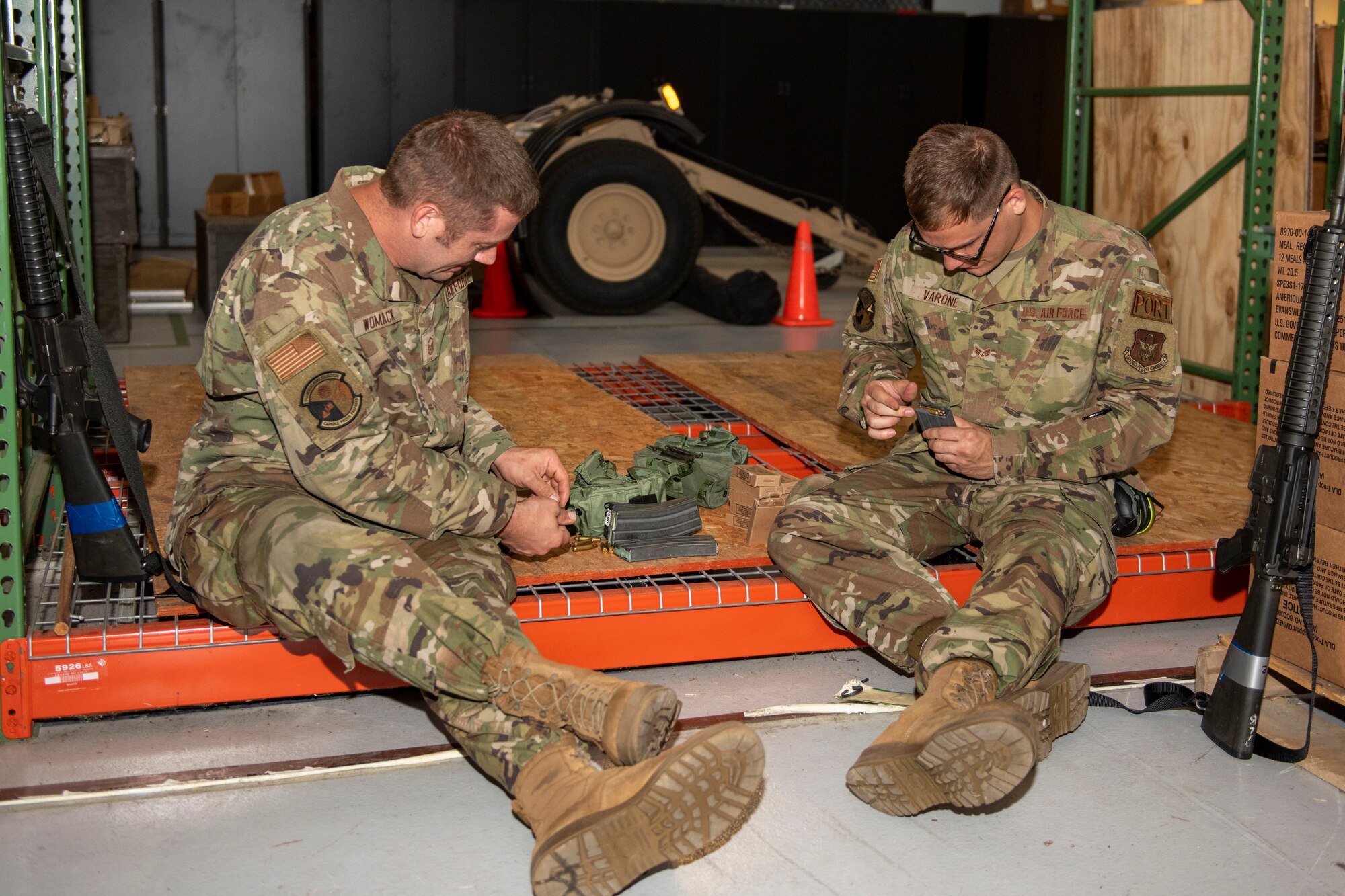 U.S. Air Force Master Sgt. Forrest Womack and Senior Airman Charles Varone, both 71st Aerial Port Squadron aerial porters, Joint Base Langley-Eustis, Va., load blank ammunition into magazines Aug. 14, 2022. The blanks were used in simulated live-fire exercises during a Joint Readiness Training Center exercise at Fort Polk, La. JRTC scenarios allow complete integration of Air Force and other military services as well as host-nation and civilian role players. The exercises replicate many of the unique situations and challenges a unit may face including host-national officials and citizens, insurgents and terrorists, news media coverage, and non-governmental organizations. (U.S. Air Force photo by Senior Airman Ruben Rios)