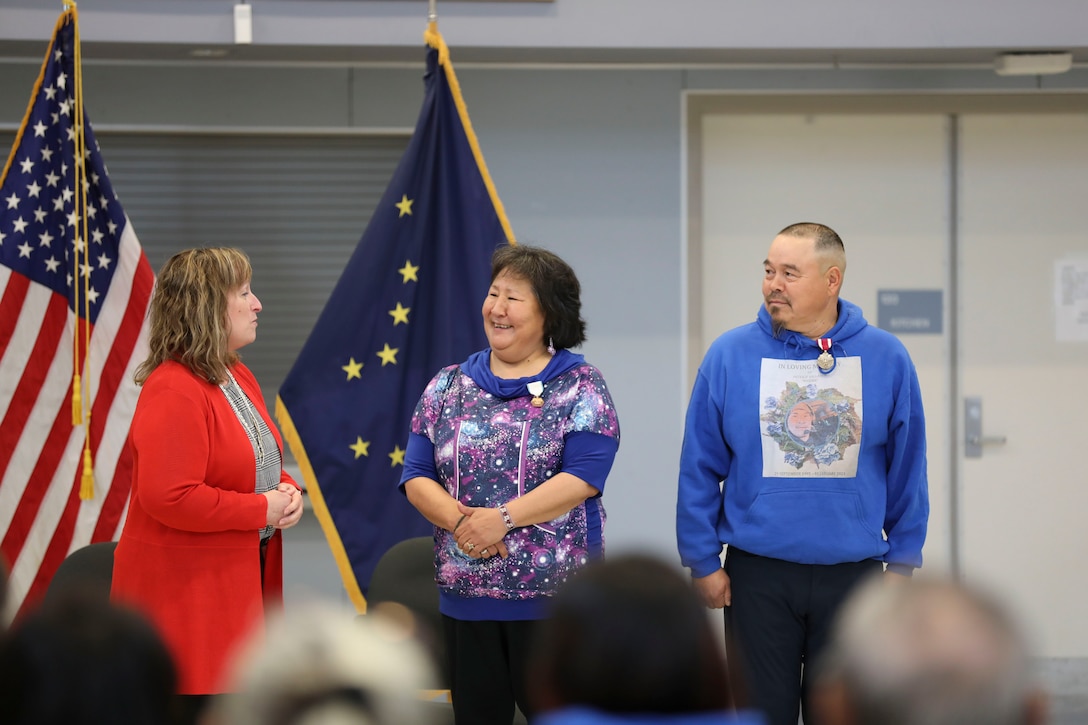 Octavia Thompson, left, the Alaska National Guard’s Warrior and Family Services director, thanks Rachel Sallaffie for her support of Guardsmen and families in the Yukon-Kuskokwim Delta area of western Alaska during a retirement ceremony for her husband, Sgt. 1st Class Joseph Sallaffie, right, at the National Guard armory in Bethel, Aug. 19, 2022.