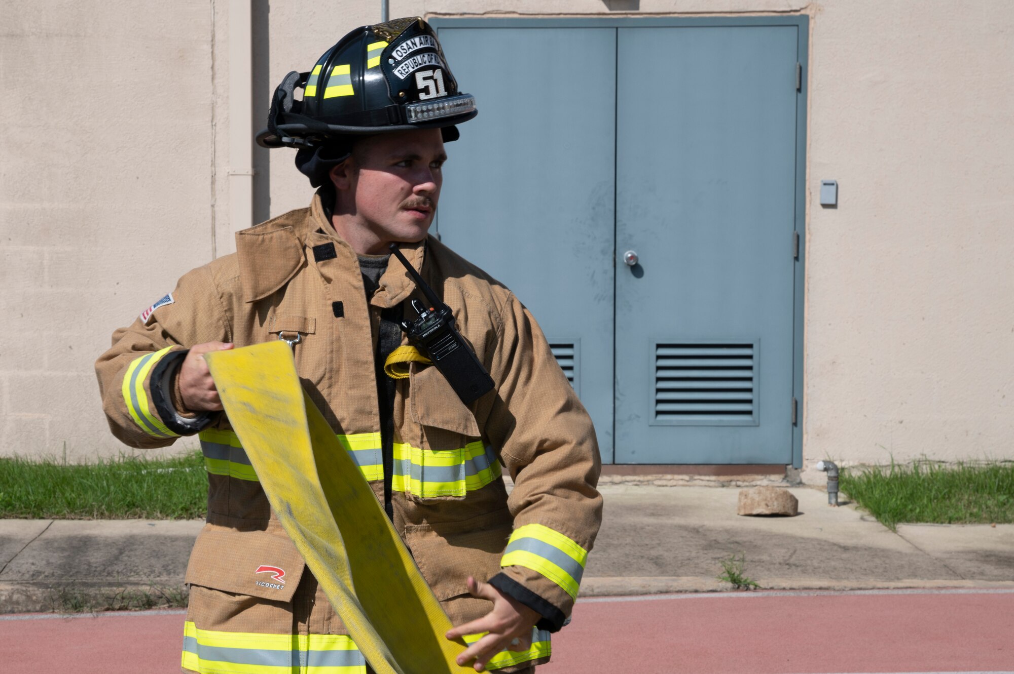 Firefighter from the 51st Civil Engineer Squadron rolls out a hose during a fire response training event at Osan Air Base, Republic of Korea