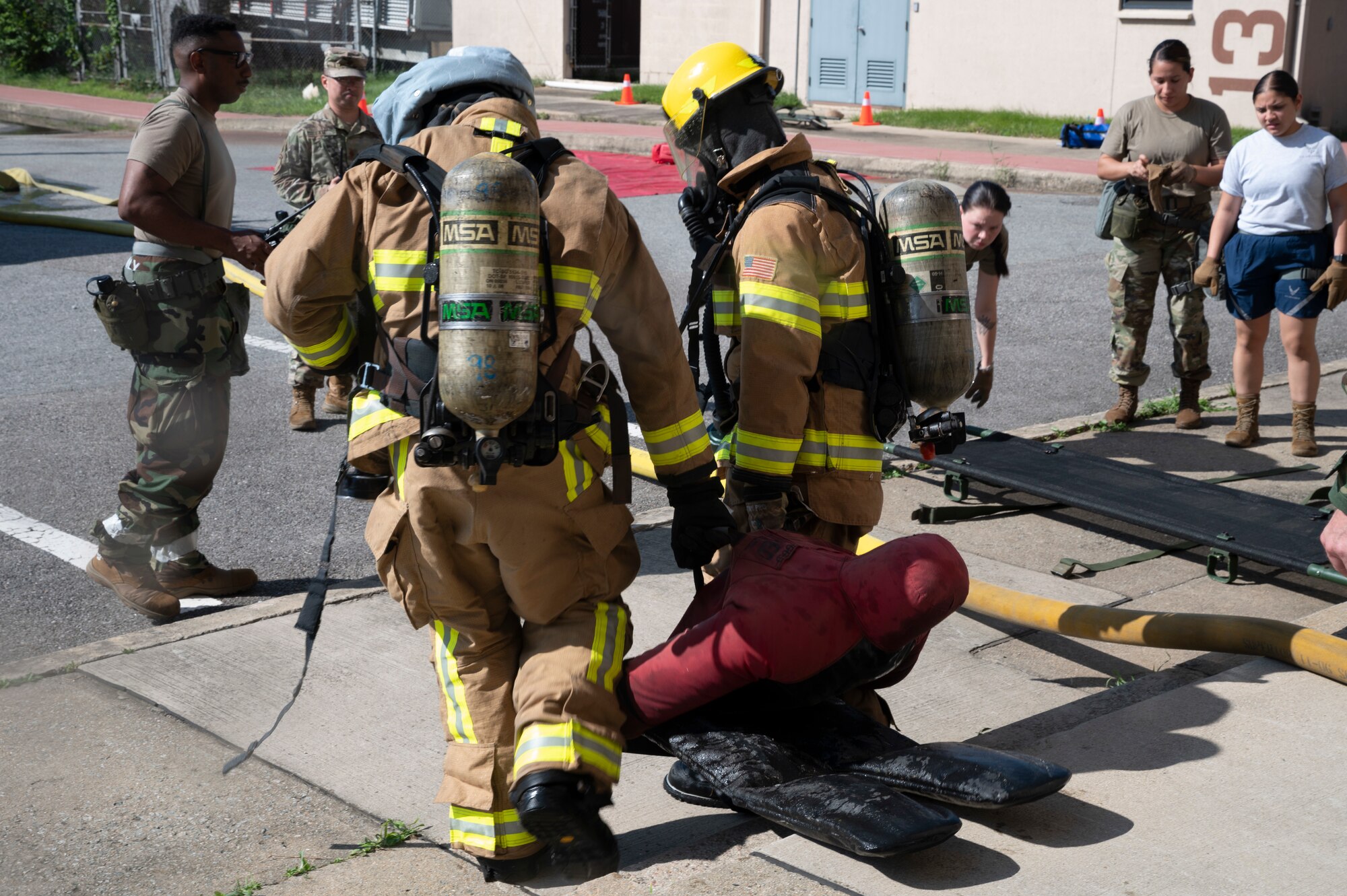 Firefighters from the 51st Civil Engineer Squadron carry out a mock victim during a fire response training event at Osan Air Base