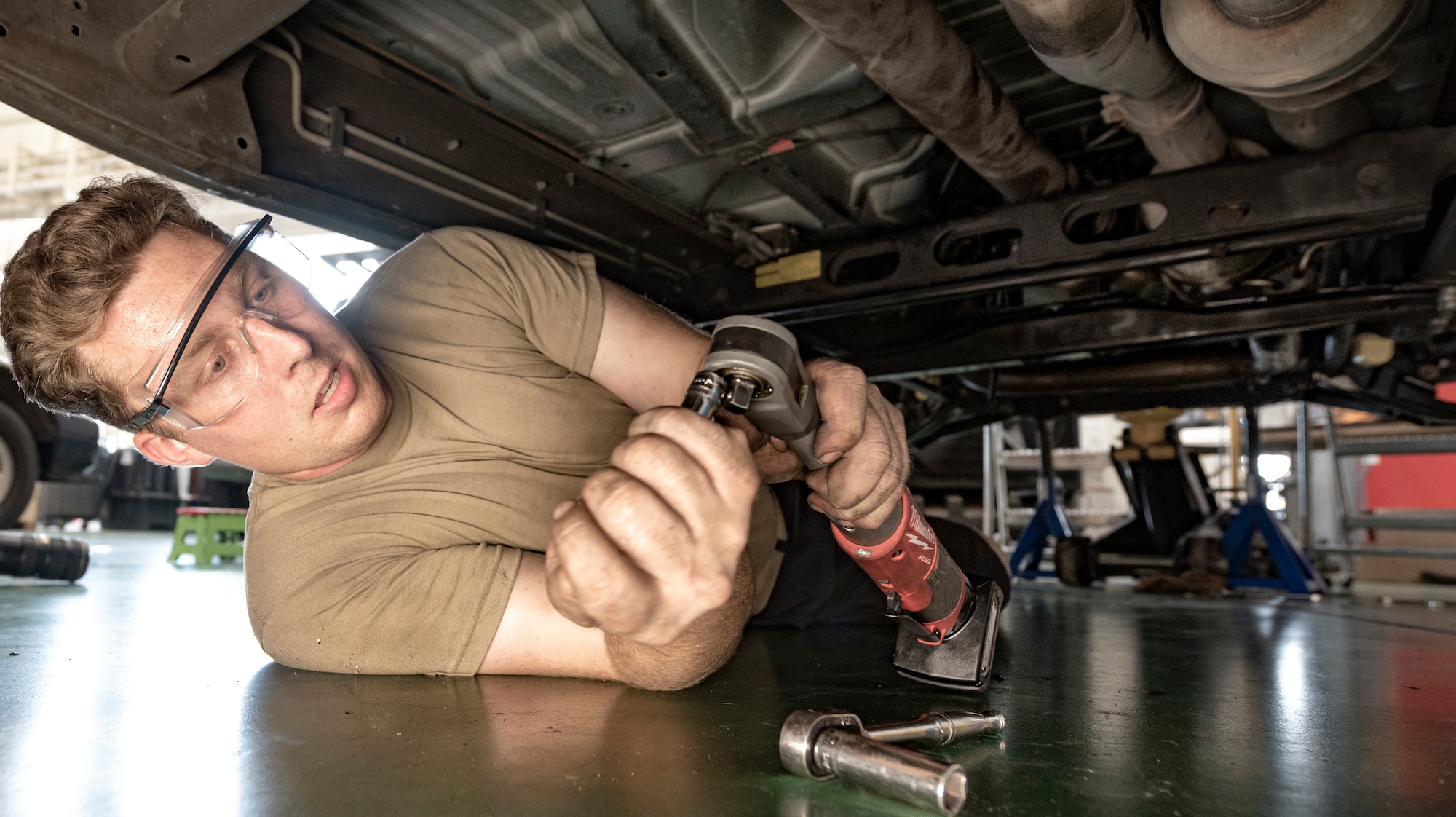 Airman 1st Class Theodore Ellis, 374th Logistics Readiness Squadron Vehicle Maintenance Flight journeyman, prepares a tool needed to reinstall the vehicle's transmission after repairing an oil leak at Yokota Air Base, Japan, Aug. 17, 2022.
