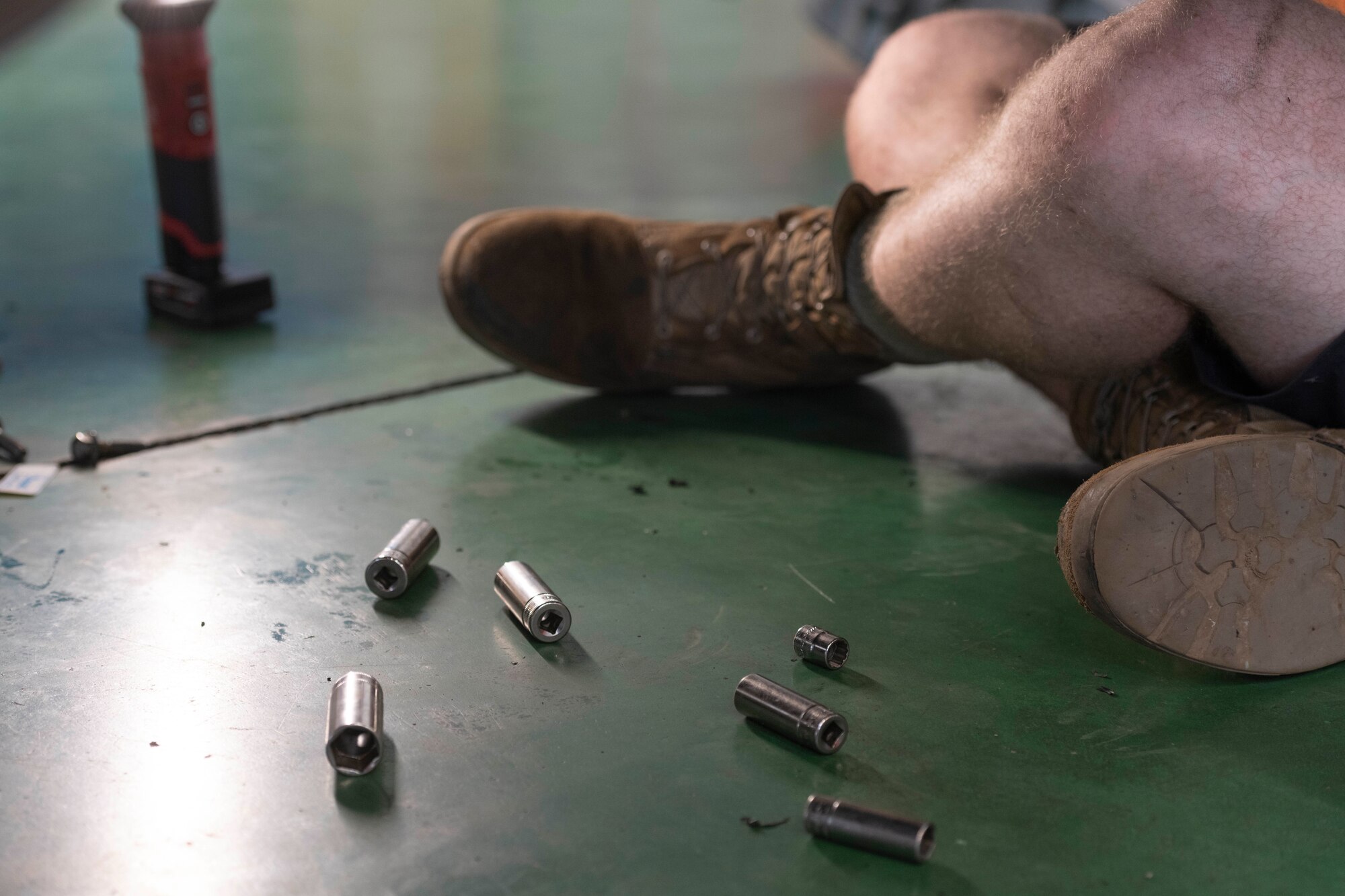 Rachet sockets belonging to the 374th Vehicle Maintenance Shop lay at the feet of Airman 1st Class Theodore Ellis, 374th Logistics Readiness Squadron Vehicle Maintenance Flight journeyman, as he reinstalls the vehicle's transmission onto a government vehicle at Yokota Air Base, Japan, Aug. 17, 2022.