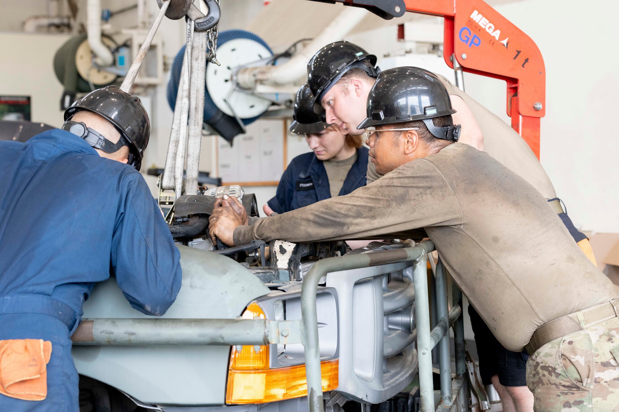 Airmen from the 374th Logistics Readiness Squadron Vehicle Maintenance Flight lift an engine out of a truck at Yokota Air Base, Japan, Aug. 17, 2022.