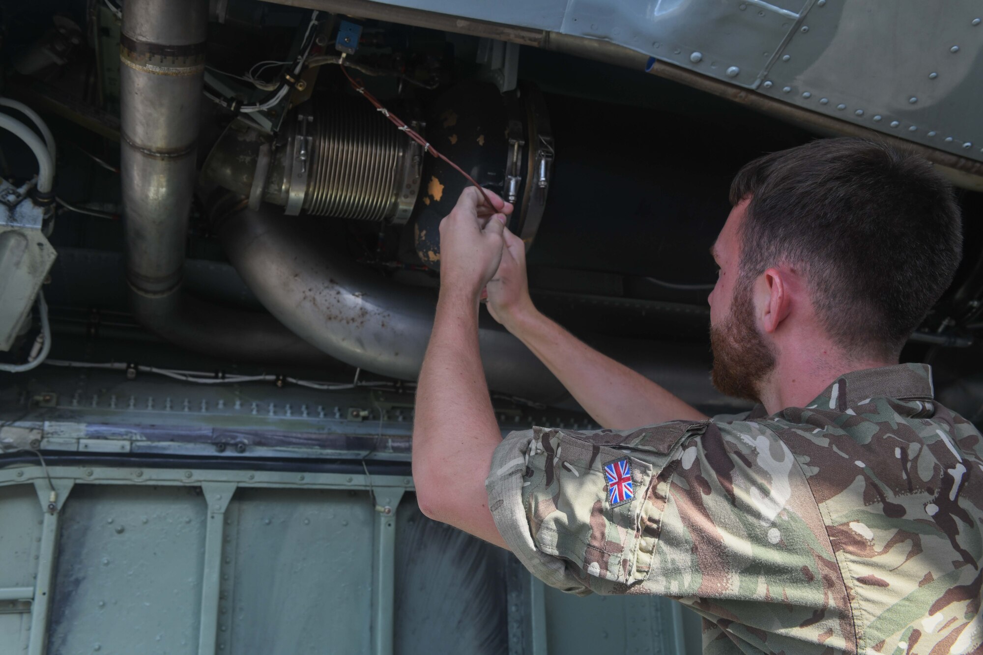 RAF aviator performs routine maintenance on an aircraft.