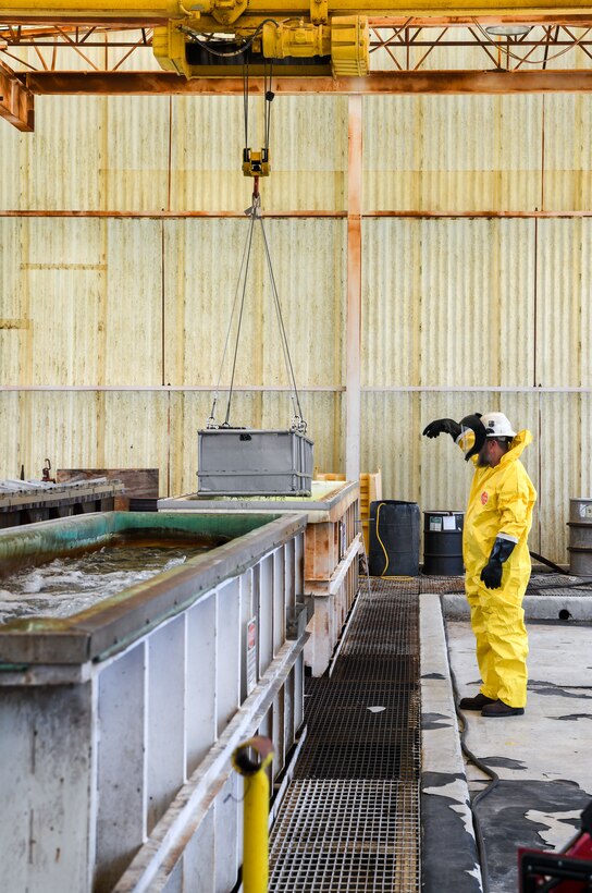 Worker in yellow Tyvek suit directing crane operations
