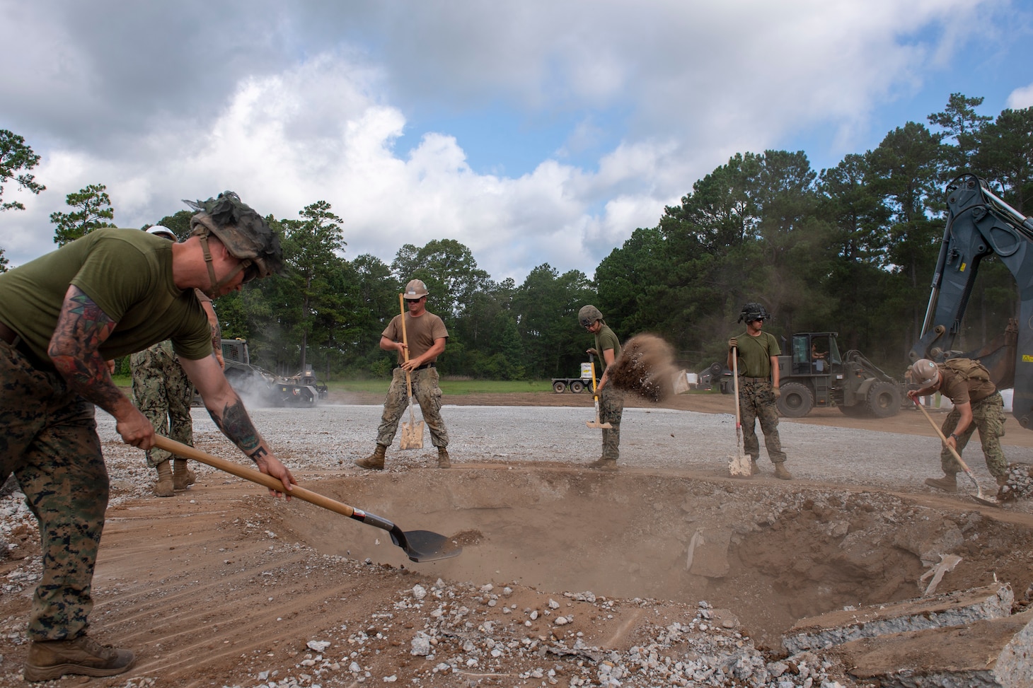 CAMP SHELBY, Miss. (Jul. 20, 2022) Seabees assigned to Naval Mobile Construction Battalion (NMCB) 1 work together with Marines assigned to Marine Wing Support Squadron (MWSS) 273 on repairing the damaged airfield during the airfield damage repair exercise during Operation Turning Point, also known as their Field Training Exercise.